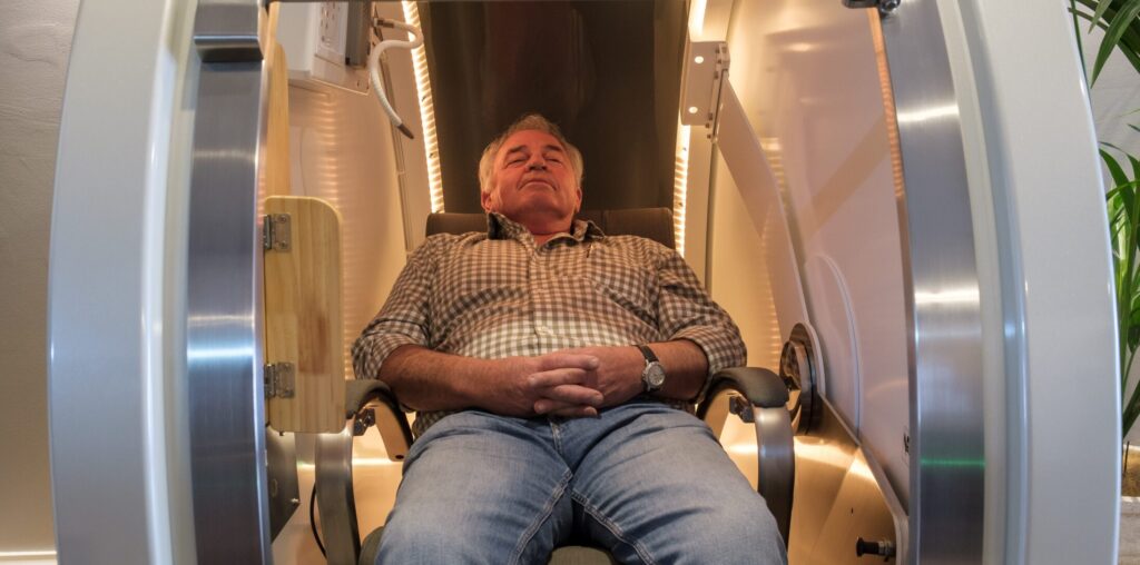 Client relaxing inside the AirPod mild hyperbaric oxygen therapy chamber at Vital 360 Ballarat